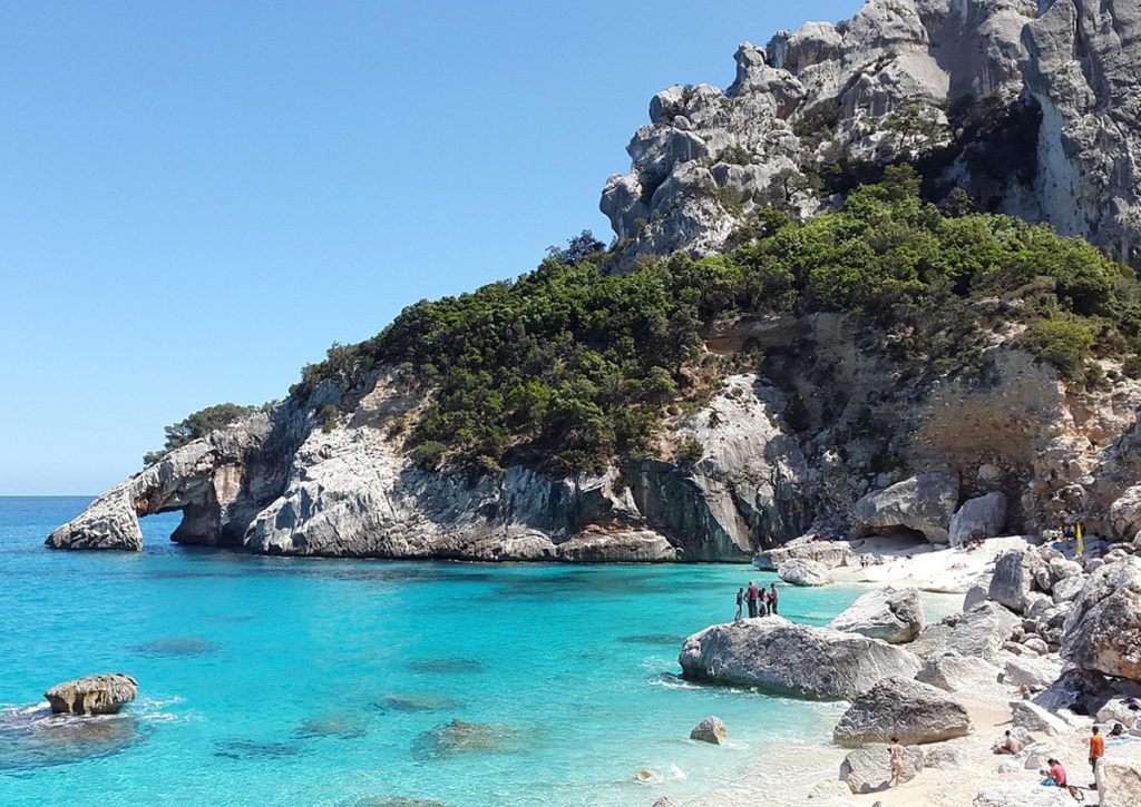 Cala Goloritzé beach with dramatic limestone pinnacle and crystal-clear turquoise waters in Sardinia
